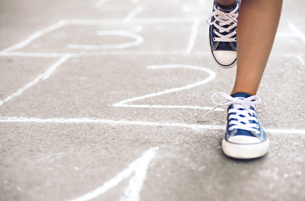Kid playing hopscotch on playground outdoors