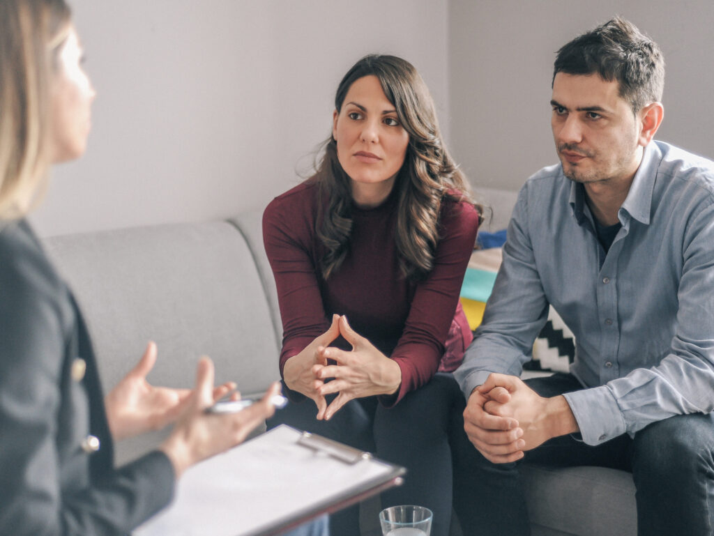 Young Couple On Counseling Appointment During Pregnancy